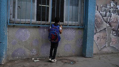 A Palestinian student looks into his classroom while he attends the first day of the new academic year at a U.N.-run school in Nuseirat, central Gaza Strip, Saturday, Sept. 19, 2026.