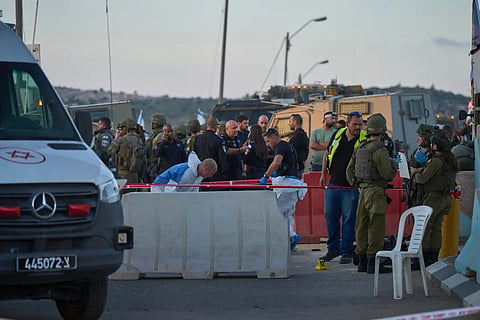 Israeli security forces inspect the scene where, according to police, a Palestinian man was shot and killed after ramming his car into a security checkpoint and seriously wounding an officer, near the West Bank Jewish settlement of Beit Horon, Wednesday, Sept. 23, 2026.
