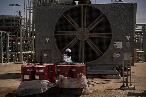 A worker collects engine oil as he works at a degassing station in Zubair oil field, whose operations have being reduced due to the Mideast war triggered by the U.S. and Israeli attacks on Iran, near Basra, Iraq, Saturday, March 28, 2026.