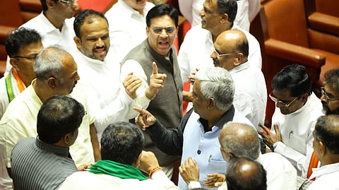 MLCs from ruling and opposition benches engage in a heated argument in the Legislative Council in Vidhana Soudha in Bengaluru on Wednesday.