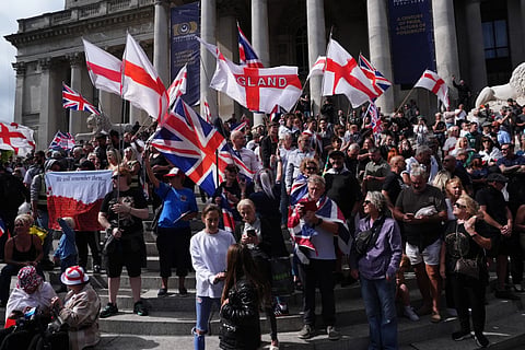 Police standby as people gather outside the Portsmouth Guildhall, Portsmouth, England, to take part in an anti-migrant South Coast Patriots march, Saturday Sept. 12, 2026.