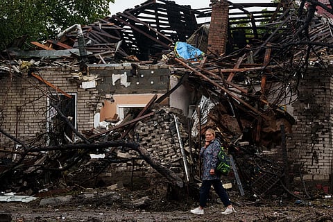 A woman walks in front of a house destroyed in a Russian strike on a residential neighbourhood in Kyiv, Ukraine, Thursday, Sept. 24, 2026.