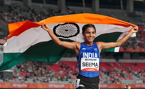 Seema celebrates with the Indian flag after the race on Thursday