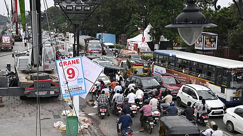 Traffic moves at a snails pace as a vehicle carrying a huge Ganesh idol stands near a crane during the immersion procession at Tank Bund in Hyderabad.