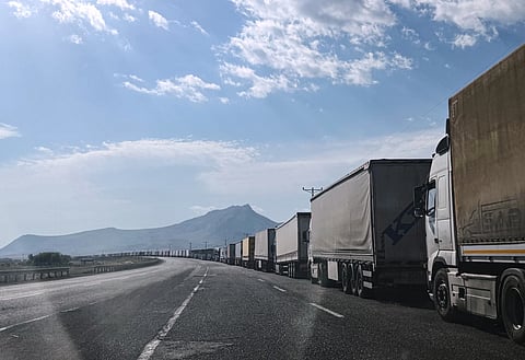 Trucks queue on the road leading to the Gurbulak border crossing on the Turkish-Iranian border in Agri province, eastern Turkey, Tuesday, Sept. 22, 2026.