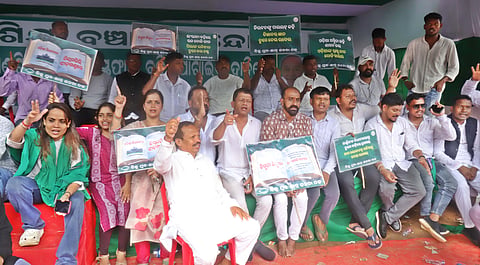 BJD members staging dharna and demanding School and Mass Education Minister Nityananda Gond regnation over errors in newly published school textbooks at Mahatma Gandhi Marg in Bhubaneswar on Wednesday.