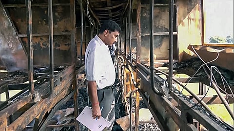 An official inspects the charred sleeper bus after it caught fire, allegedly caused by the driver and cleaner's continuous smoking on the Yamuna Expressway, in Greater Noida on Thursday. 
