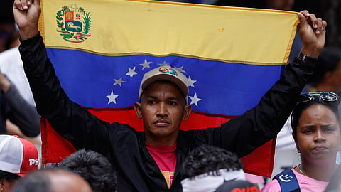 A man holds a Venezuelan national flag during a government-organised rally in support of acting President Delcy Rodriguez in Caracas, Venezuela, Wednesday, Sept. 23, 2026.