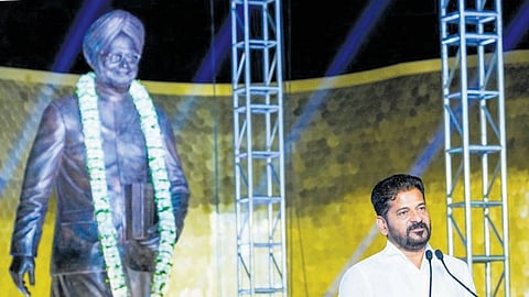 Chief Minister A Revanth Reddy addresses the gathering after unveiling a  statue of former prime minister Manmohan Singh at Wipro Junction, Financial District, in Hyderabad on  Saturday. 