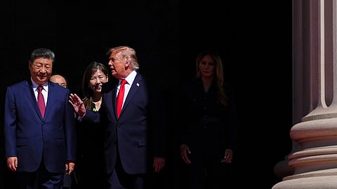 US President Donald Trump speaks with China President Xi Jinping as first lady Melania Trump walks at right, at the National Archives Museum on Friday in Washington