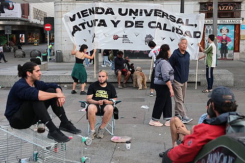 Demonstrators install a banner reading 'Universal housing, qualitative and free' one day after a protest against evictions and the housing crisis