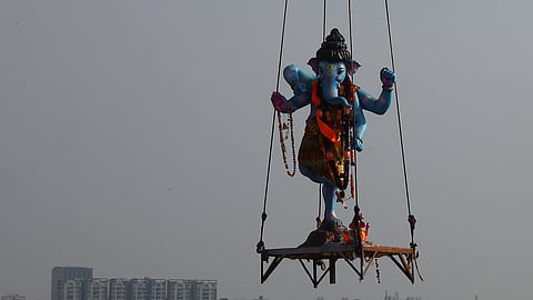 An idol of lord Ganesha is lifted with cranes for immersion in the Hussainsagar in Hyderabad on Saturday.