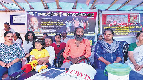 Residents of P&T Colony stage a demonstration demanding the immediate demolition of the existing structure and allotment of new housing units