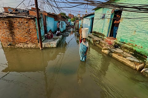 Residents of a low-lying neighborhood watch as floodwaters submerge their area following heavy rains in Kanpur, India, on Sept. 22, 2026. 