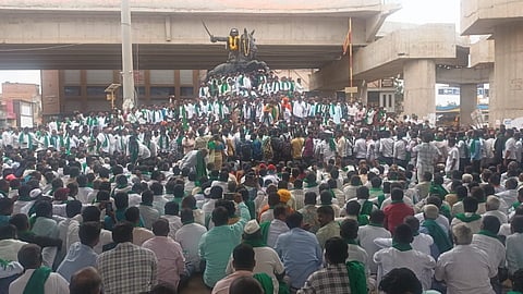 The protesting sugarcane farmers at Rani Chennamma Circle on Tuesday.