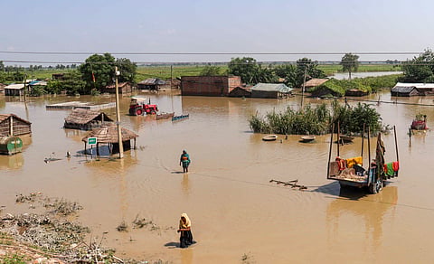 People wade through a partially inundated area, at Khairatwa village in West Champaran, Tuesday, Sept. 29, 2026.