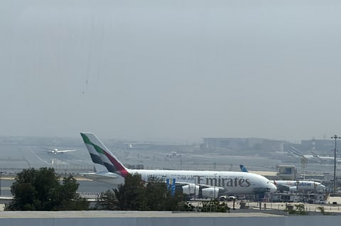 A FlyDubai plane, upper left, lands as Emirates and other FlyDubai aircraft sit on the tarmac at Dubai International Airport in Dubai, United Arab Emirates, Wednesday, Sept. 30, 2026.