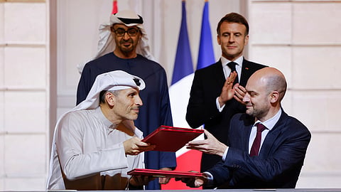 France's President Emmanuel Macron, rear right, and United Arab Emirates President Sheikh Mohamed bin Zayed Al Nahyan, rear left, look on as France's Minister for Europe and Foreign Affairs Jean-Noel Barrot, right, and CEO of Mubadala Investment Company Khaldoon Al Mubarak, left, sign an agreement on AI at the Elysee Palace in Paris, Feb. 6, 2025.