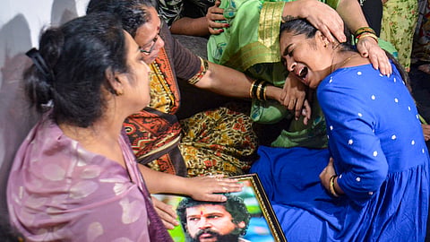 Vijeta Purnekar, wife of slain Shiv Sena (UBT) division chief Pradeep Purnekar, and their daughter, in blue, grieve while holding a portrait of Purnekar at their residence, in Thane, Thursday, Oct. 1, 2026.