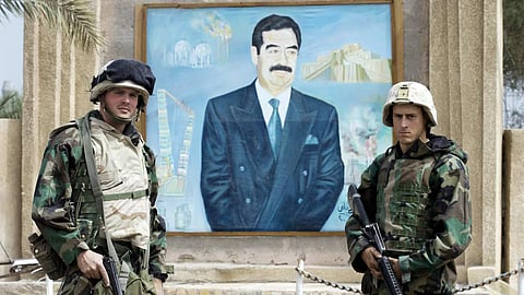 US Marines pose for a souvenir picture in front of a portrait of Iraqi President Saddam Hussein in 2003 in Nasiriyah