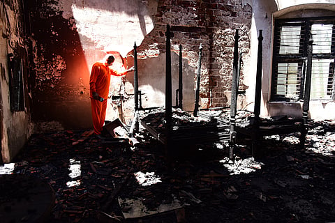 Fire Force personnel inspect the charred remnants of the historic Kader House following a devastating fire that gutted the heritage structure late last night.