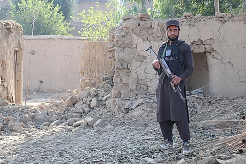 A Taliban security personnel stands guard near a damaged house, after Pakistani airstrike struck Gurbuz district in Afghanistan's Khost province on September 24, 2026.