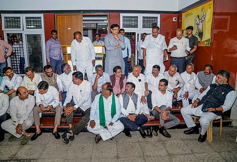 Karnataka Chief Minister DK Shivakumar, right, along with cabinet colleagues and party leaders stages a sit-in demonstration outside the office of Chief Electoral Officer V. Anbukkumar, in Bengaluru, Thursday, Oct. 1, 2026.