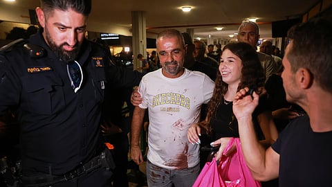 Israeli passenger Yaniv Hayoun, with blood stains on his shirt, who was aboard a Flydubai aircraft that made an emergency landing in Saudi Arabia, is welcomed at the arrivals gate at Ben Gurion International Airport near Tel Aviv, Israel, Wednesday, Sept. 30, 2026.