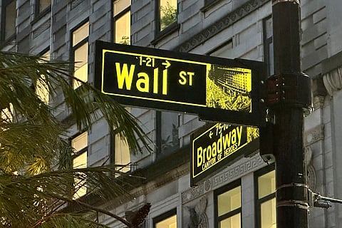 Signs mark the intersection of Wall Street and Broadway in New York's Financial District. 