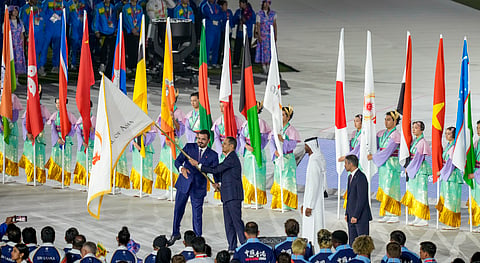 Qatar Prime Minister Sheikh Mohammed bin Abdulrahman bin Jassim Al-Thani (R) & Olympic Council of Asia (OCA) chief Sheikh Joaan bin Hamad Al-Thani (L) take part in the handover of the OCA flag during the closing ceremony 