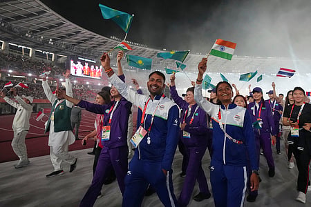 Indian athletes walk in arms as they leave the arena following the closing ceremony for the Asian Games in Nagoya, Japan on Sunday