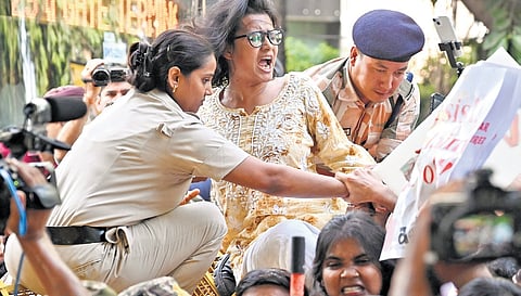 AISA national president Neha Bora climbs a police barricade during a protest demanding the removal of the CEC on Sunday; 