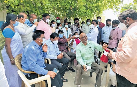Officials interacting with villagers of the bird flu-affected poultry farm area at Siddarampuram village of Anantapur district.
