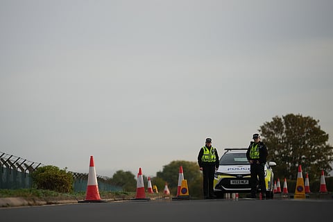 Police officers guard a road leading to RAF Fairford, after an incident in Fairford, England, Monday Sept. 28, 2026