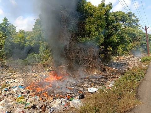 Municipal waste set on fire along the Perumbakkam reserve forest on Monday  