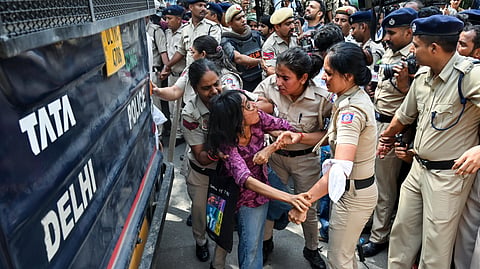 Police detain a woman protester near Jantar Mantar during a protest seeking Chief Election Commissioner Gyanesh Kumar's resignation over voter roll deletions, in New Delhi.