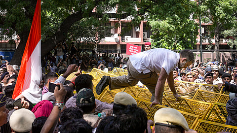 Leader of Opposition in the Lok Sabha Rahul Gandhi climbs atop police barricades after being stopped by security personnel during a protest march from Parliament towards the Election Commission of India (ECI) office, demanding the resignation of Chief Election Commissioner Gyanesh Kumar, in New Delhi, Tuesday, Oct. 6, 2026