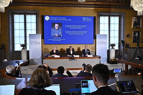 A portrait of Francis Halzen is shown on the screen as Eva Olsson, Ellen Moons, and Mark Pearce announce as the recipient of the 2026 Nobel Prize in Physics during a press conference at the Royal Swedish Academy of Sciences, Stockholm, Sweden, Oct. 6, 2026.