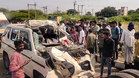 People gather around a mangled SUV following a collision with a trailer truck near Trapaj village on the Bhavnagar-Talaja highway, in Bhavnagar district, Gujarat, Tuesday, Oct. 6, 2026.