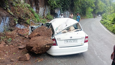  Due to the wet conditions, a boulder reportedly slipped from the hillside and fell onto the car.