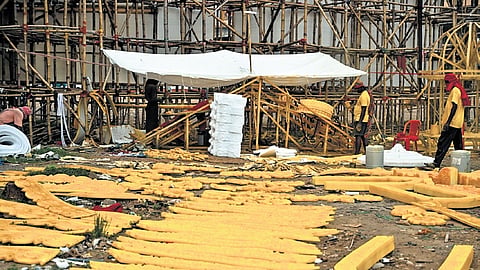 Men making decorative designs using polyethylene foam sheets to be installed at Rasulgarh Durga Puja mandap in Bhubaneswar, on Wednesday.