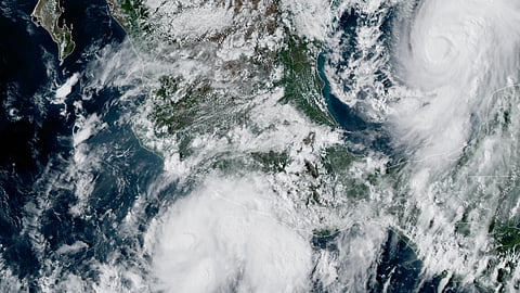 This GOES-19 GeoColor satellite image taken on Oct. 7, 2026, shows Tropical Storm Simon, bottom center, in the Pacific Ocean, off the southwestern coast of Mexico, and Tropical Storm Isaias, upper right, east of Mexico in the Gulf of Mexico. 