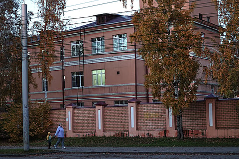 A woman with her child walks past the building of the Irkutsk Anti-Plague Research Institute of Siberia and the Far East in Irkutsk, Russia, on Wednesday, Oct. 7, 2026. 