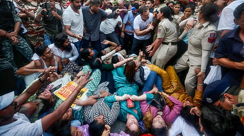 Lok Sabha LoP Rahul Gandhi stops Delhi Police from detaining Congress MP Priyanka Gandhi Vadra and others during the INDIA bloc MPs' protest against Chief Election Commissioner Gyanesh Kumar near Jantar Mantar, in New Delhi on Wednesday.