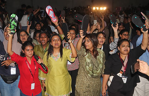 Women demonstrators hold up their slippers during the ‘Chappal protest’ organised by the CJP at Freedom Park on Thursday.