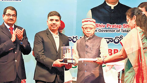 Governor Shiv Pratap Shukla presents an outstanding RTI performance award to Nalgonda District Collector B Chandrashekhar, in Hyderabad on Friday.