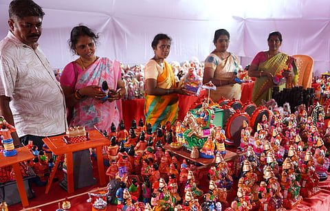 Golu dolls arranged on shelves for sale at the Poompuhar expo in Madurai ahead of Navratri, as customers browse the traditional figurines to decorate their homes for the festival.