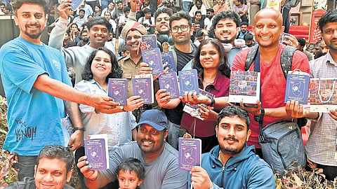 People show ‘philately passports’ they purchased from India Post on the occasion of National Postal Day at the GPO in Bengaluru on Saturday.