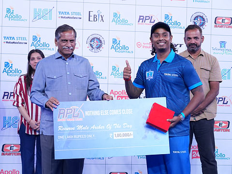 Anil Kamineni (L) hands out the cash prize to archer Atanu Das during the APL