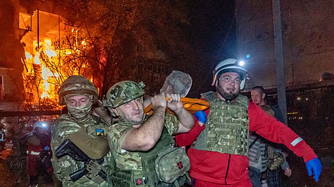 Rescuers evacuate an injured civilian after a residential building was hit following a Russian air attack in Kharkiv, Ukraine, Tuesday, Oct. 13, 2026. 